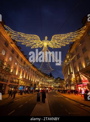 Londres, Royaume-Uni - novembre 20 2023 : Regent Street dans le centre de Londres avec des lumières de Noël au-dessus. Les gens font du shopping de Noël et admirent le décor festif Banque D'Images