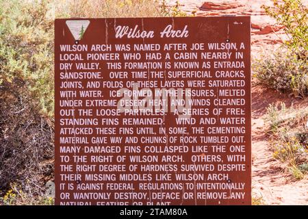 Signez à Wilson Arch dans l'Utah. Situé à 24 miles au sud de Moab sur la US 191, Wilson Arch est une arche spectaculaire en grès naturel (appelée Entrada Sandstone). Banque D'Images