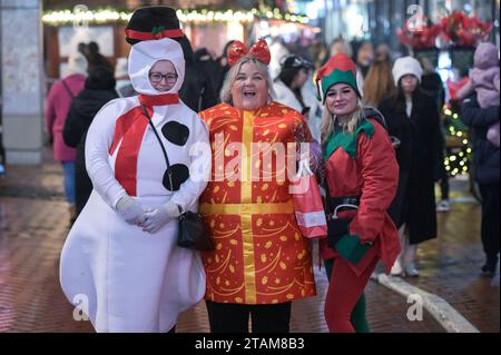 New Street, Birmingham 1 décembre 2023 - Revellers est allé au centre-ville de Birmingham vendredi soir portant des tenues de Noël alors que la saison des fêtes commence. Plusieurs ont été vus marchant le long de la tristement célèbre bande de vie nocturne de Broad Street dans des groupes de travail. Un groupe de dames portaient une robe de fantaisie de Noël, y compris une dinde, germe, le North Star et plusieurs rennes. D'autres ont été repérés portant un bonhomme de neige, un cadeau et des tenues d'elfe le long de New Street dans le centre-ville. Des centaines de personnes se sont également emballées dans le marché de Francfort sur la place Victoria. Malgré le brouillard glacial et les températures inférieures à zéro, une partie Banque D'Images