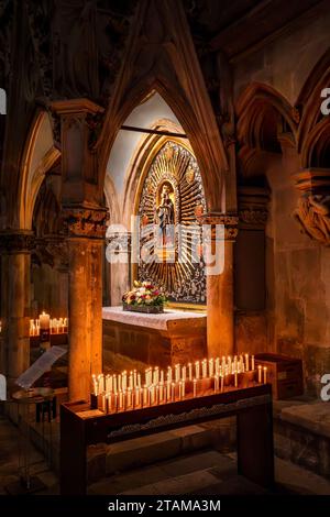 Regensburg, Bavière – DE – 5 juin 2023 vue intérieure verticale de l’autel notre-Dame de la cathédrale de Ratisbonne avec des bougies votives ou des bougies de prière. Banque D'Images