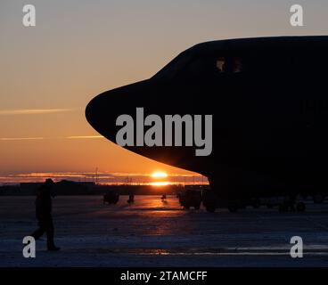 Le soleil se lève derrière un B-52H Stratofortress à la base aérienne de Minot, Dakota du Nord, le 28 novembre 2023. Le B-52H peut transporter une charge utile allant jusqu'à 70 000 livres. (Photo de l'US Air Force par l'aviateur de 1e classe Alyssa Bankston) Banque D'Images