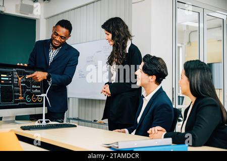 Les collègues collaborent dans un bureau moderne sur un projet de démarrage, en mettant l'accent sur le travail d'équipe. Trois personnes Banque D'Images