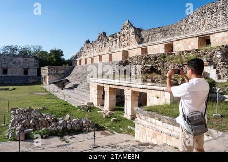 Tourist prend une photo avec son téléphone portable du quadrilatère des religieuses sur le site archéologique d'Uxmal à Yucatán, au Mexique Banque D'Images