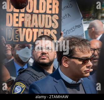 Central Islip, États-Unis. 10 mai 2023. Une pancarte de protestation est placée derrière George Santos, représentant de la Chambre des représentants pour le 3e district du Congrès de New York, alors qu'il parle à la presse devant la Cour fédérale. George Santos, représentant de la Chambre des représentants pour le 3e district du Congrès de New York, comparaît devant la cour fédérale à Central Islip, long Island après avoir plaidé non coupable à 13 accusations fédérales pour avoir induit en erreur les donateurs et dénaturé ses finances auprès du public et des agences gouvernementales. (Photo de Derek French/SOPA Images/Sipa USA) crédit : SIPA USA/Alamy Live News Banque D'Images