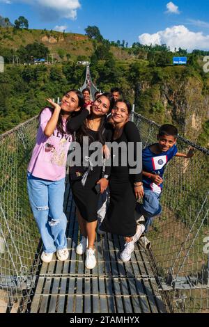 Les jeunes filles népalaises sur le plus long pont suspendu au monde traverse la gorge de la rivière Kali Gandaki - Mustang District, Népal Banque D'Images