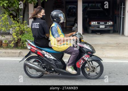 SAMUT PRAKAN, THAÏLANDE, septembre 30 2023, chauffeur de taxi en moto avec une femme. Banque D'Images