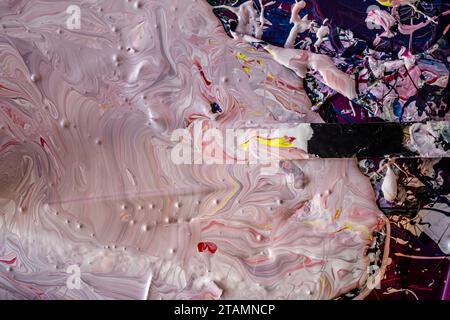 Peinture marbrée dans Studio Pink Red Swirl Mix Acrylic Mess Banque D'Images