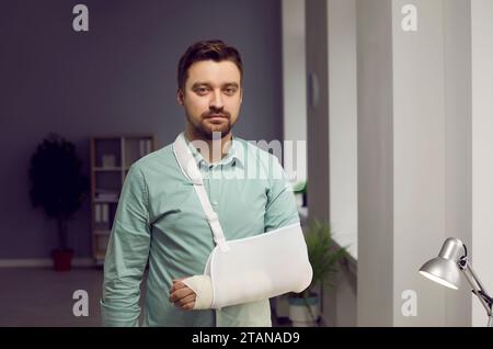 Jeune homme au bras cassé portant une attelle Banque D'Images