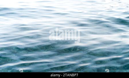 Vagues de mer turquoise clair roulant sur la plage. Banque D'Images