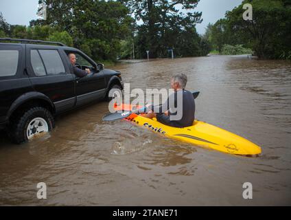 (231202) -- BEIJING, 2 déc. 2023 (Xinhua) -- Un homme fait du kayak dans une rue inondée à Auckland, Nouvelle-Zélande, 14 février 2023. Le gouvernement néo-zélandais a déclaré l’état d’urgence national le 14 février, avant que le cyclone Gabrielle ne déchaîne toute sa fureur. Ce n ' est que la troisième fois dans l ' histoire de la Nouvelle-Zélande qu ' un état d ' urgence national est proclamé. Vagues de chaleur, pluies torrentielles, inondations, sécheresses et autres catastrophes naturelles se sont succédé dans le monde ces dernières années. Tout en étant impressionnés par la puissance puissante et la vulnérabilité de la nature, nous le sentons sincèrement quand il s'agit de tack Banque D'Images