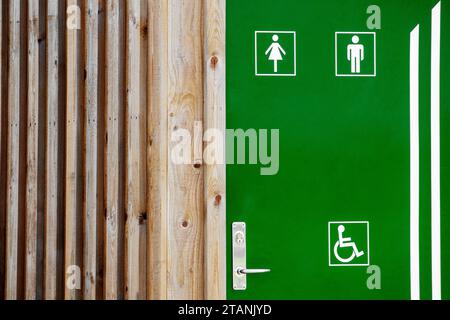 une maison en bois avec une porte verte et avec des marques d'ordonnance sur elle Banque D'Images