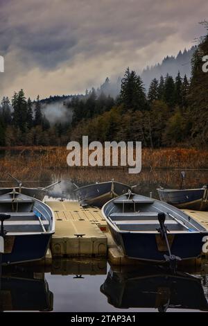 Les barques en bois garées sur un quai en bois situé près d'un plan d'eau. Banque D'Images