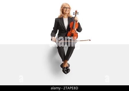 Femme avec un violon assis sur un panneau blanc isolé sur fond blanc Banque D'Images