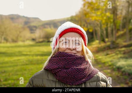 portrait de femme mature avec bonnet d'hiver et écharpe faisant la détox numérique Banque D'Images