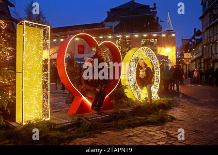 Quedlinburg, Allemagne. 02 décembre 2023. Les visiteurs ont leur photo prise devant les décorations illuminées de l'Avent. L'Avent dans les cours a été autour pendant de nombreuses années et cette année attire des centaines de milliers de visiteurs de près et de loin à la ville le week-end jusqu'au 17 décembre. Crédit : Matthias Bein/dpa/Alamy Live News Banque D'Images