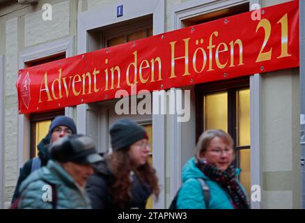 Quedlinburg, Allemagne. 02 décembre 2023. Les visiteurs passent devant un panneau avec l'inscription 'Advent in den Höfen'. Advent in den Höfen existe depuis de nombreuses années et cette année attire des centaines de milliers de visiteurs de près et de loin dans la ville le week-end jusqu'au 17 décembre. Crédit : Matthias Bein/dpa/Alamy Live News Banque D'Images