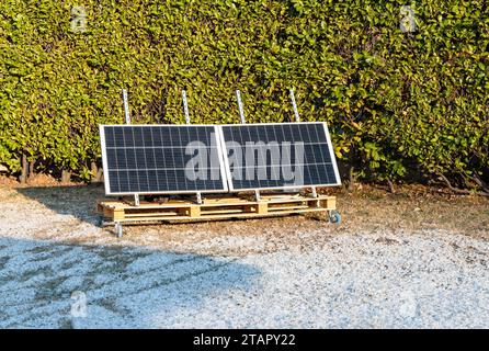 Panneaux photovoltaïques sur la palette en bois dans le jardin de la maison à l'heure d'hiver. Concept d'énergie verte. Banque D'Images