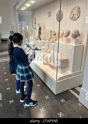 Un couple d'élèves dessinant de petites têtes sculptées au Metropolitan Museum of Art de New York. Banque D'Images