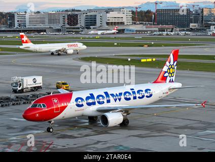 Airbus de la compagnie aérienne suisse de loisirs Edelweiss Air, derrière un avion de Swiss International Air Lines sur la piste, aéroport de Zurich, Suisse Banque D'Images