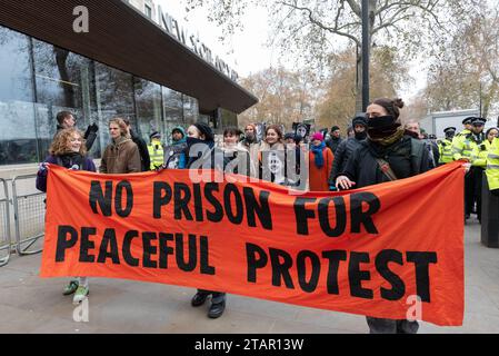 Londres, Royaume-Uni. 2 décembre 2023. Les militants du climat de Just Stop Oil (JSO) se rassemblent devant le siège de la police métropolitaine à New Scotland Yard avant de se rendre devant la Cour suprême en solidarité avec les militants emprisonnés ou placés en détention pour s’être opposés pacifiquement à l’expansion de l’extraction de combustibles fossiles. Crédit : Ron Fassbender/Alamy Live News Banque D'Images