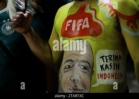 Surakarta, Java central, Indonésie. 2 décembre 2023. Un spectateur a été vu peindre son corps avec le visage du président de la FIFA, Gianni Infantino avant de regarder le match de finale de la coupe du monde U-17 de la FIFA entre l'Allemagne et la France au stade Manahan. (Image de crédit : © Angga Budhiyanto/ZUMA Press Wire) USAGE ÉDITORIAL SEULEMENT! Non destiné à UN USAGE commercial ! Banque D'Images