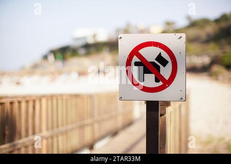 Rouge et noir, pas de chiens autorisés, panneau sur le chemin en bois menant à la plage Banque D'Images