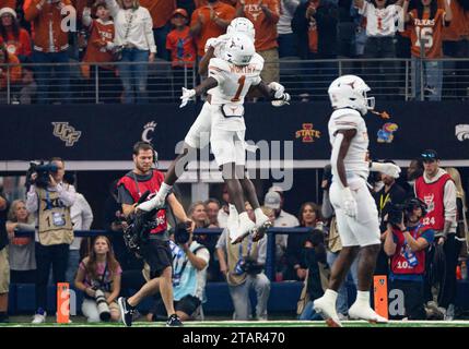 Arlington, Texas, États-Unis. 2 décembre 2023. Le receveur Texas Longhorns Wide Adonai Mitchell (5) et le receveur Texas Longhorns Wide Xavier Worthy (1) célèbrent un touchdown lors de la 1e moitié du match de football NCAA entre les Oklahoma State Cowboys et les Texas Longhorns au AT&T Stadium d'Arlington, Texas. Matthew Lynch/CSM/Alamy Live News Banque D'Images