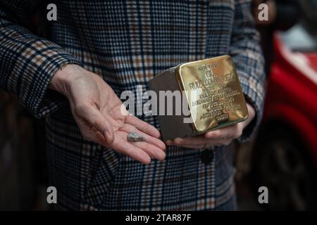 Madrid, Espagne. 01 décembre 2023. Un participant tient une Stolpersteine avant d'être installé. Ce matin, de nouvelles unités de 'Stolpersteine' ont été placées à Madrid, cette fois dans le quartier d'Arganzuela, afin de se souvenir des républicains espagnols, déportés dans les camps d'extermination nazis. Le projet Stolpersteine est l’œuvre de l’artiste allemand Gunter Demnig, en hommage à toute victime du nazisme entre 1933 et 1945, y compris les déportés espagnols. Crédit : SOPA Images Limited/Alamy Live News Banque D'Images