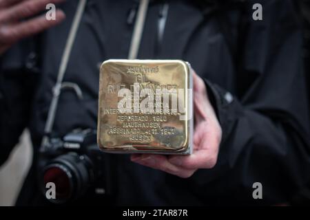 Madrid, Espagne. 01 décembre 2023. Un participant tient une Stolpersteine avant d'être installé. Ce matin, de nouvelles unités de 'Stolpersteine' ont été placées à Madrid, cette fois dans le quartier d'Arganzuela, afin de se souvenir des républicains espagnols, déportés dans les camps d'extermination nazis. Le projet Stolpersteine est l’œuvre de l’artiste allemand Gunter Demnig, en hommage à toute victime du nazisme entre 1933 et 1945, y compris les déportés espagnols. Crédit : SOPA Images Limited/Alamy Live News Banque D'Images