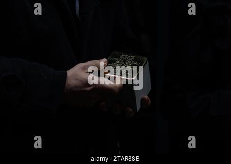 Madrid, Espagne. 01 décembre 2023. Un participant tient une Stolpersteine avant d'être installé. Ce matin, de nouvelles unités de 'Stolpersteine' ont été placées à Madrid, cette fois dans le quartier d'Arganzuela, afin de se souvenir des républicains espagnols, déportés dans les camps d'extermination nazis. Le projet Stolpersteine est l’œuvre de l’artiste allemand Gunter Demnig, en hommage à toute victime du nazisme entre 1933 et 1945, y compris les déportés espagnols. Crédit : SOPA Images Limited/Alamy Live News Banque D'Images