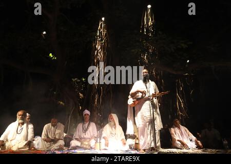 Sirajdikhan, Munshiganj, Bangladesh. 2 décembre 2023. En mémoire de Fakir Lalon Shah, les artistes Baul interprètent Lalangiti (chansons) lors de la réunion annuelle de discussion et de rassemblement des sadhus à Padmahem Dham à Sirajdikhan, Munshiganj. Lalon était un saint humanitaire. Il s'est éloigné de toutes sortes de différences raciales, y compris la religion, la caste et a donné à l'humanité la plus haute place. Il a composé toutes les chansons de son attitude non communautaire. Ce Bengali aux multiples talents est également connu sous les noms de Fakir Lalon, Lalon Sai, Lalon Shah, Mahatma Lalon etc Il est un saint faqir spirituel, humaniste, réformateur social et p Banque D'Images