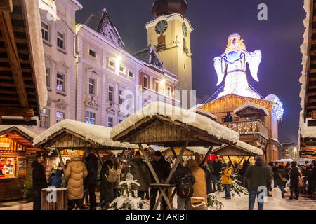 Wels : marché de Noël ('Weihnachtswelt') sur la place Stadtplatz, stands enneigés, statue de Christkind, église Stadtpfarrkirche à Zentralraum, OBE Banque D'Images