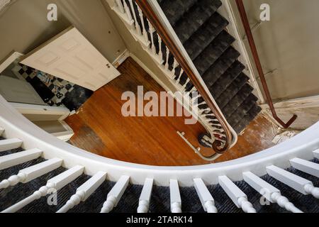 Une vue de haut en bas d'un vieil escalier en bois à l'intérieur d'une maison abandonnée. Banque D'Images