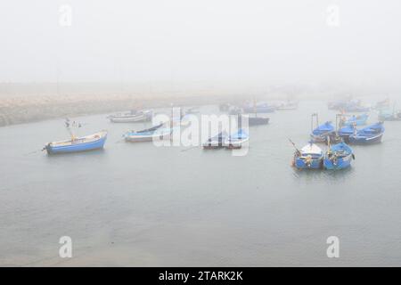 photo brute non éditée de bateaux de pêche dans un port par temps brumeux Banque D'Images