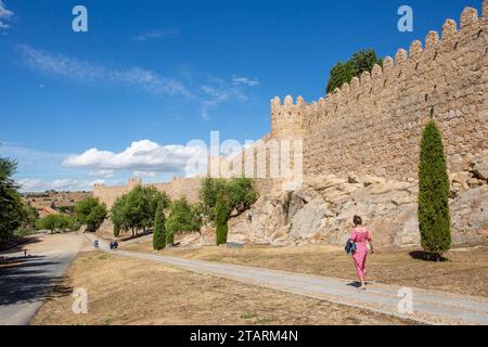 Femme marchant le long des remparts et fortifications dans la ville fortifiée espagnole d'Avila dans la communauté autonome de Castille-et-León Espagne Banque D'Images