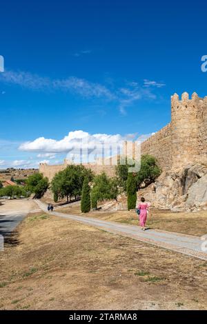 Femme marchant le long des remparts et fortifications dans la ville fortifiée espagnole d'Avila dans la communauté autonome de Castille-et-León Espagne Banque D'Images