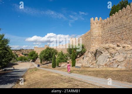 Femme marchant le long des remparts et fortifications dans la ville fortifiée espagnole d'Avila dans la communauté autonome de Castille-et-León Espagne Banque D'Images