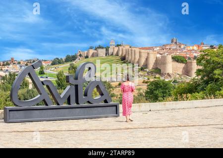 Femme admirant la vue d'un point de vue au-dessus de la ville fortifiée espagnole d'Avila Banque D'Images