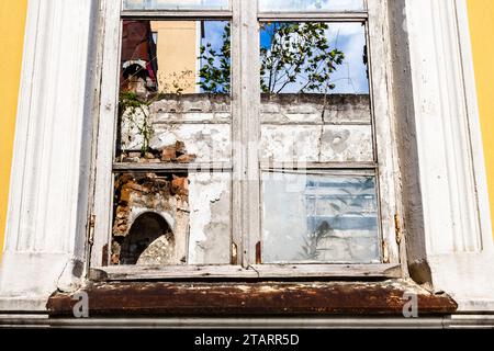 Voyage en Géorgie - vue de face de verre cassé dans le cadre de fenêtre dans la maison urbaine abandonnée dans le centre-ville de Batumi ville Banque D'Images