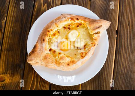 Voyage en Géorgie - vue de dessus de khachapuri dans le style Adjarian (bateau en forme de fromage à pâte molle, oeuf, beurre) dans un café local dans la ville de Batoumi Banque D'Images