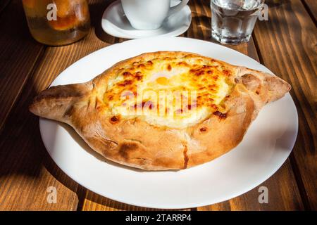 Voyage en Géorgie - Adjarian khachapuri illuminé par le soleil dans le café en plein air local dans la ville de Batumi Banque D'Images