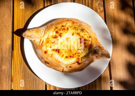 Voyage à la Géorgie - vue de dessus de Adjarian khachapuri illuminé par le soleil dans le café en plein air local dans la ville de Batoumi Banque D'Images