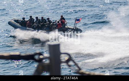 Les marins de l'US Navy montent dans un bateau pneumatique à coque rigide pour commencer les exercices Visit, Board, Search & Seizure à bord du destroyer à missiles guidés USS Mason (DDG 87) dans le golfe d'Aden le 22 novembre 2023. Dans le cadre du Dwight D. Eisenhower Carrier Strike Group (IKECSG), le Mason est déployé dans la zone d'opérations de la 5e flotte américaine pour soutenir la sécurité maritime et la stabilité au Moyen-Orient. (Photo de l'US Navy par Samantha Alaman, spécialiste des communications de masse de 3e classe) Banque D'Images