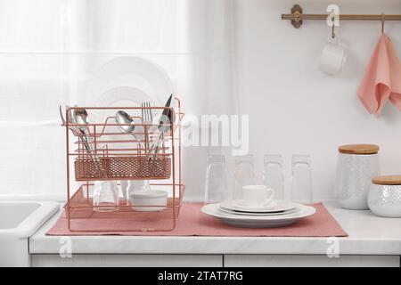 Séchoir avec vaisselle propre et couverts sur le comptoir dans la cuisine Banque D'Images