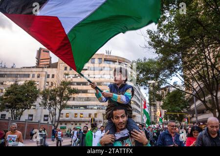 29 novembre 2023, BogotÃ, Colombie : un enfant sur les épaules de son père agite le drapeau palestinien pendant la manifestation. Marche à BogotÃ pour la Journée internationale de solidarité avec le peuple palestinien. (Image de crédit : © Antonio Cascio/SOPA Images via ZUMA Press Wire) USAGE ÉDITORIAL SEULEMENT! Non destiné à UN USAGE commercial ! Banque D'Images