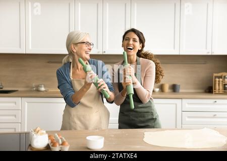 Mère aînée joyeuse et fille adulte appréciant l'activité culinaire Banque D'Images