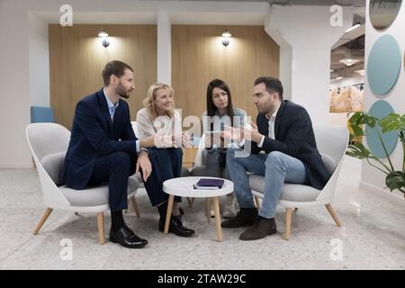 Le personnel réuni dans le hall moderne des bureaux prend part au briefing Banque D'Images