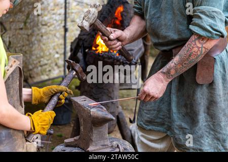 Démonstration de forge dans une forge en forme de tête de dragon pendant la fête médiévale au château de Bonaguil, France Banque D'Images