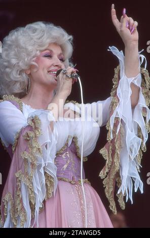 Superstar Dolly Parton se produisant sur scène lors d'un concert lors de sa tournée dans le Midwest en 1978, son geste de main levée offre une bonne vue de ses longs ongles. Banque D'Images