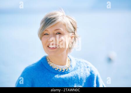 Portrait en plein air de belle femme de 55 - 60 ans, portant un pull bleu Banque D'Images